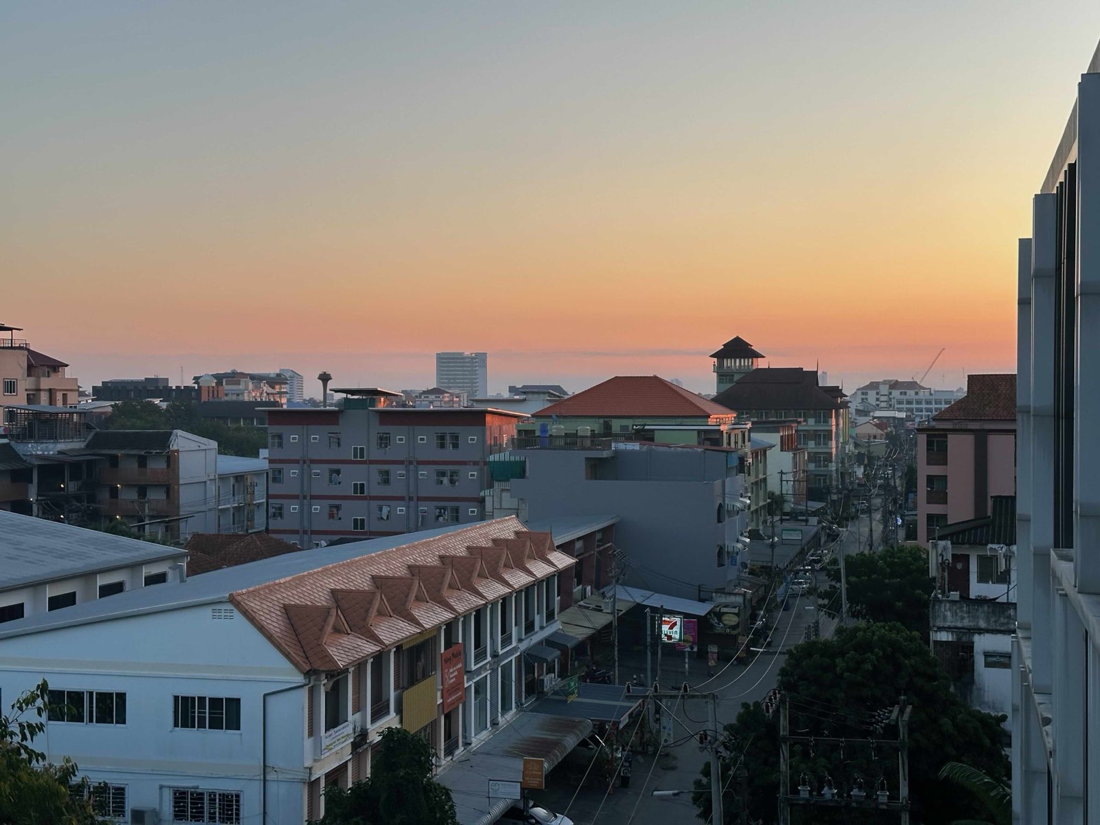 Sunset over the low-rise rooftops of Chiang Mai, seen from a condo balcony