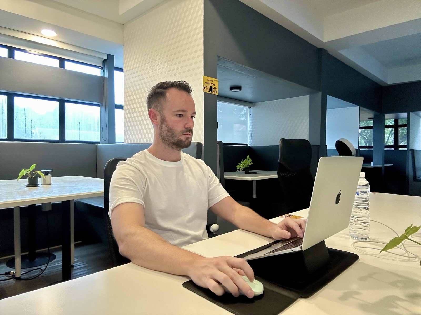 Dan working on a laptop at a table in a Chiang Mai coworking space